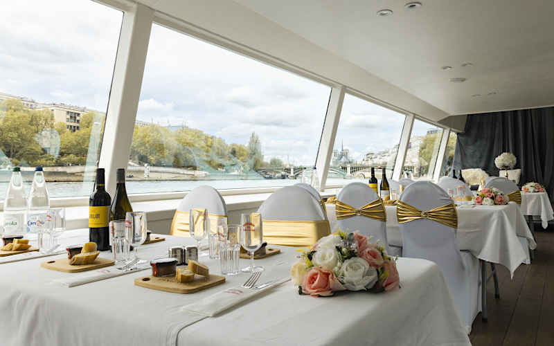 Mesas decoradas para una cena de bodas a bordo de una barcaza en el Sena