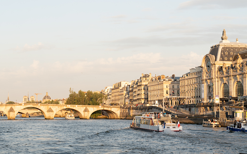 Vista del Sena al atardecer con el museo d'Orsay y un barco en primer plano